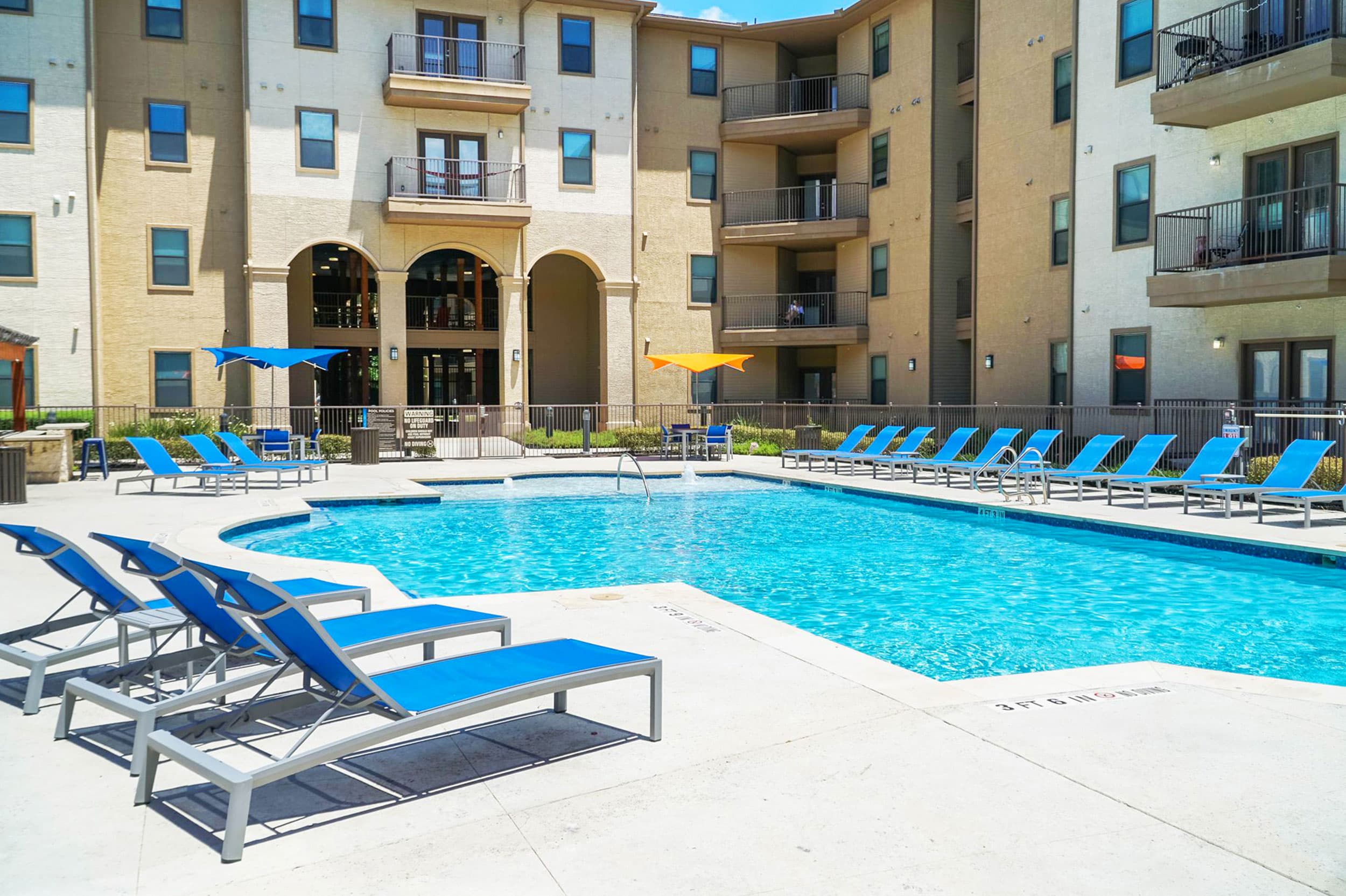 outdoor pool area with lounge chairs at prado student living apartments